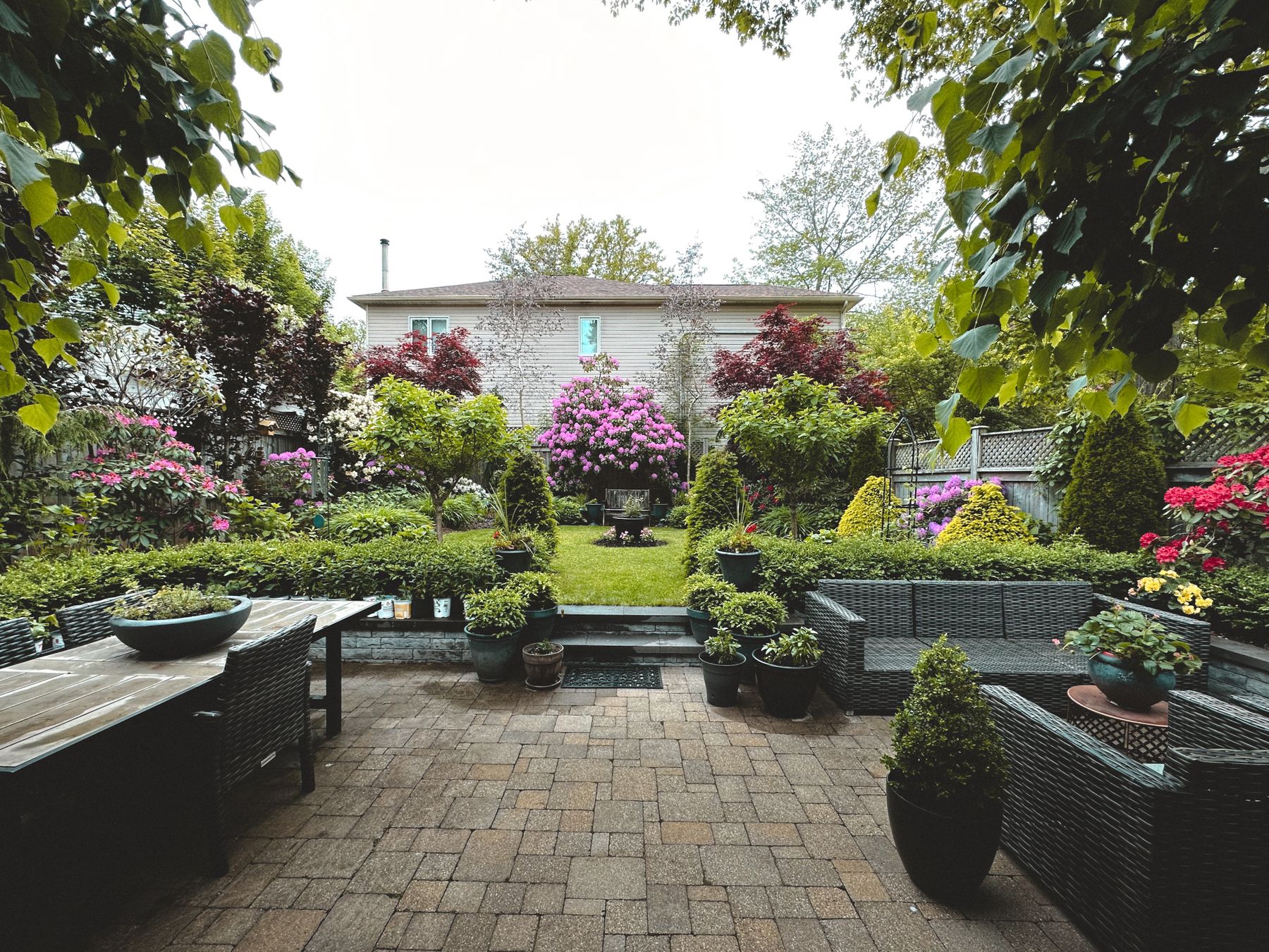 Backyard garden with colorful flower borders and patio seating